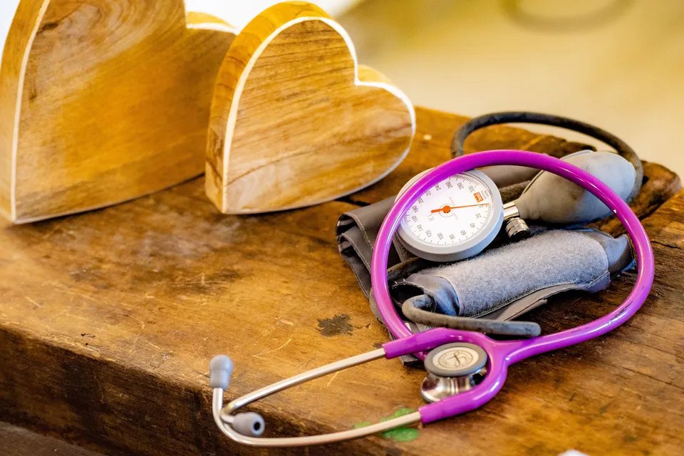Medizinisches Equipment und Holzherzen auf einem Tisch.